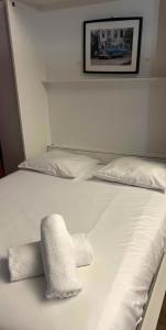 a white bed with two white pillows on it at Charming studio at the foot of the Opera-Le Petit Pradel in Lyon