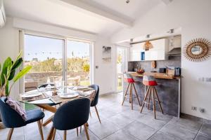 Una cocina y un comedor con mesa y sillas. en VUEMER Bandol - GRANDE TERRASSE de 45m2 VUE MER PISCINE PARKING, en Bandol