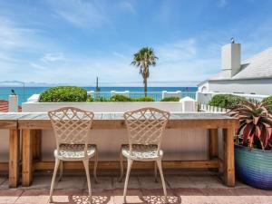 a large wooden table with two chairs and the ocean at St James Beachfront Villa in St James +15 photos