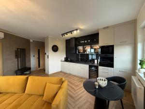 a living room with a yellow couch and a table at Apartament KALINA in Chojnice
