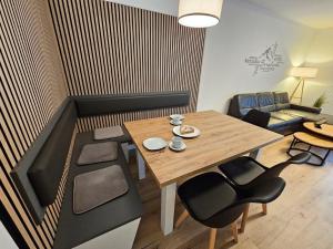 Ferienhaus Nr 96, Kategorie Komfort Plus, Feriendorf Hochbergle, Allgäu في Karlsebene: غرفة معيشة صغيرة مع طاولة وكراسي خشبية
