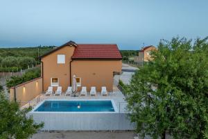 a house with a swimming pool next to a house at Villa Stella ZadarVillas in Gornje Biljane