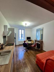 a room with a kitchen and a bed and a table at L'aparté Dijonnaise Hypercentre Dijon Darcy in Dijon