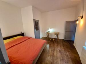 a bedroom with an orange bed and a desk at L'aparté Dijonnaise Hypercentre Dijon Darcy in Dijon