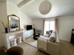 a living room with a couch and a mirror at Loft du Mistral Charme Cinéma Allauch in Allauch