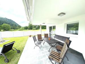 a patio with chairs and a table with a view at Ferienhaus Au Villa in Söll