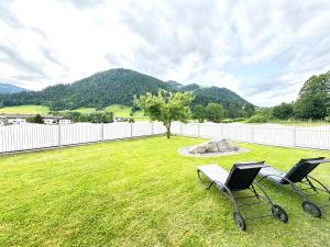 two chairs sitting in a yard with a fence at Ferienhaus Au Villa in Söll