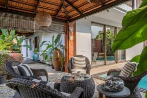 GoaにあるDacha - Super Luxury 4bhk villa with poolのパティオ(椅子、テーブル、プール付)
