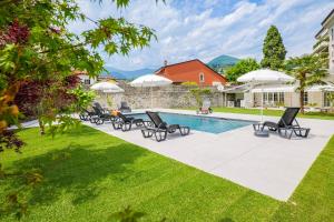 Un grupo de sillas y sombrillas junto a una piscina en Villa Rachel Trilo, en Intra