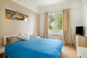 a bedroom with a blue bed and a window at Appartement Dans Villa in Villeneuve-Loubet