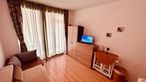 a living room with a television and a large window at Sunny Day 6 Studio 11 in Sunny Beach