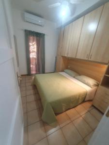 a small bedroom with a bed and a window at La Bouganville in Villasimius