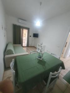 a living room with a green table and a couch at La Bouganville in Villasimius