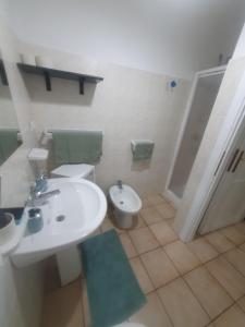 a white bathroom with a sink and a toilet at La Bouganville in Villasimius +5 photos