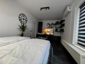 a bedroom with a bed and a clock on the wall at Panda Apartment Zorilor in Cluj-Napoca