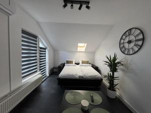 a bedroom with a bed and a clock on the wall at Panda Apartment Zorilor in Cluj-Napoca