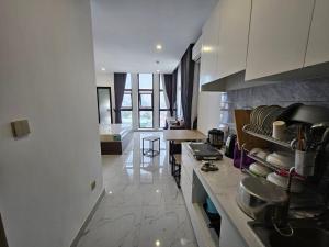 a kitchen with white cabinets and a counter with pots and pans at The Vincent Condo in Phumĭ Prêk Chrey