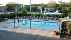 a swimming pool with a fence around it at The Braemar Condominium in North Truro