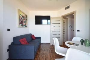 Una sala de estar con un sofá azul y una mesa. en Akoya Lux Shore - YourPlace Abruzzo, en Torino di Sangro