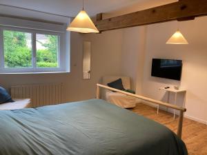 a bedroom with a bed and a flat screen tv at Les Coquelets in Hamars