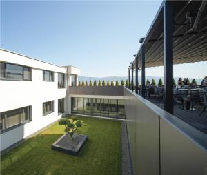 a large white building with a courtyard with grass at Tsar Samuil Hotel in Strumica