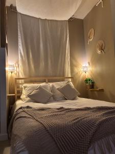 a bedroom with a large bed with two lights at La parenthèse balinaise in Cholet