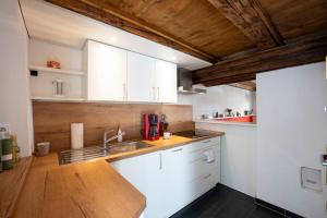 バンベルクにあるBunter Hund Apartments - ganzes historisches Altstadthausの白いキャビネットと木製の天井が備わるキッチン +25枚の写真