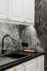 a kitchen with white cabinets and a sink at Neptun Park Premium by NorthSide Apartments in Gdańsk +51 photos
