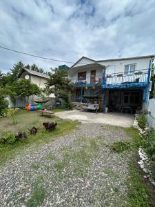a large white house with a balcony and a yard at SOPHIE GuestHouse in Grigoleti