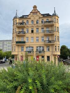 a tall yellow building with windows and balconies at Apartament Fyrtel in Poznań