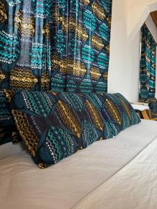 a bed with black and gold pillows on it at TRANQUIL RESORT HOTEL in Brusubi +32 photos