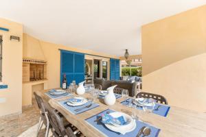 ein Esszimmer mit einem Holztisch und Stühlen in der Unterkunft Luxury villa next beach Cabo Roig in Orihuela