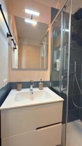 a bathroom with a white sink and a shower at Izz Home in Naples
