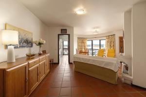 a bedroom with a bed and a table and chairs at Sunset Bay São Martinho do Porto in São Martinho do Porto +7 photos