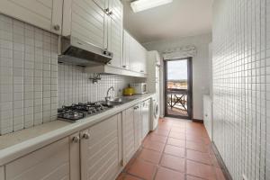a kitchen with white cabinets and a tile floor at Sunset Bay São Martinho do Porto in São Martinho do Porto