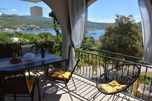 a balcony with a table and chairs and a view of the water at Maris Rogoznica in Rogoznica