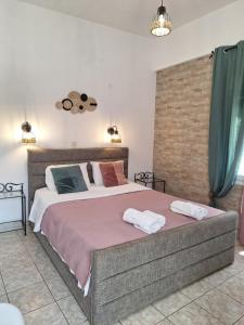 a bedroom with a large bed with two towels on it at Vithos in Agnontas