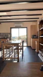 Un comedor con una mesa y un gran ventanal. en Gîte charme et nature Drôme, en Chantemerle-les-Blés