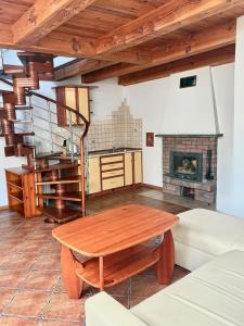 a living room with a wooden table and a fireplace at Camping Morski 21 in Łeba