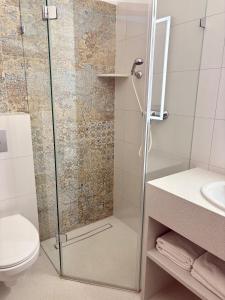 a bathroom with a shower with a toilet and a sink at Camping Morski 21 in Łeba +19 photos