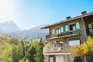a building on a hill with mountains in the background at Le Bellacha in La Léchère