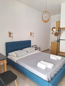 a bedroom with a blue bed with towels on it at Vithos in Agnontas