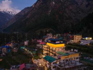 eine Stadt mit Gebäuden und einem Berg im Hintergrund in der Unterkunft The Hosteller Kasol, Parvati Valley in Kasol