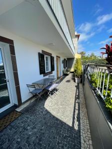 a patio with a table and chairs next to a building at Casa de Sao Tiago 1 in Funchal
