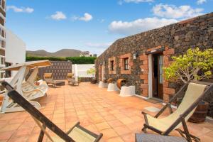 a patio with chairs and a brick building at Casa Rural La Molina in Máguez