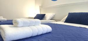 a hotel room with two beds with towels on them at Sa Trunfa Rooms in Tortolì