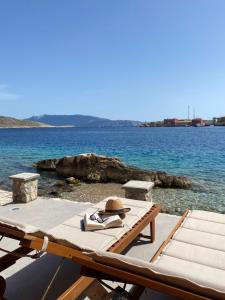 哈尔基岛NUMĒNIA Seafront Property的船上有一张野餐桌，上面有一顶帽子和一本书