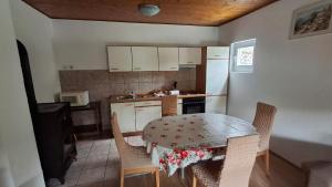 a kitchen with a table and chairs and a refrigerator at Guesthouse Marić in Stolac