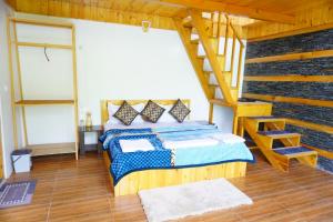 a bedroom with a bed and a staircase in a room at Acoustic Himalayas Jibhi in Jibhi