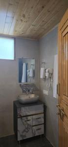 a bathroom with a sink and a mirror at Acoustic Himalayas Jibhi in Jibhi
